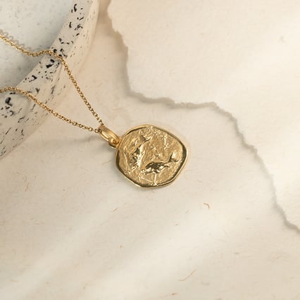 Zlatý prívesok so symbolmi znamenia zverokruhu Ryby