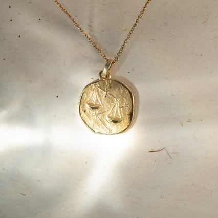 Zlatý prívesok so symbolmi znamenia zverokruhu Váhy