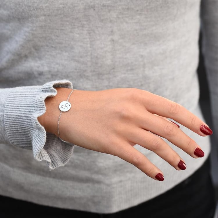 Náramok so znamením a granátom Kozorožec z bieleho zlata 47686