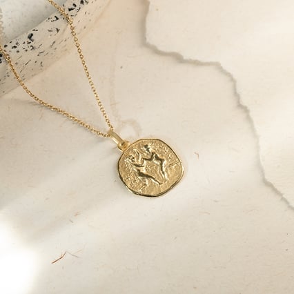 Zlatý prívesok so symbolmi znamenia zverokruhu Blíženci